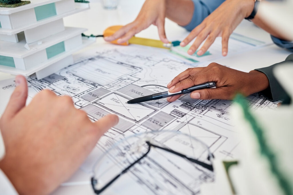 Architect's hands and blueprint for building collaboration, illustrating the planning and discussion process for accurate as-built drawings.